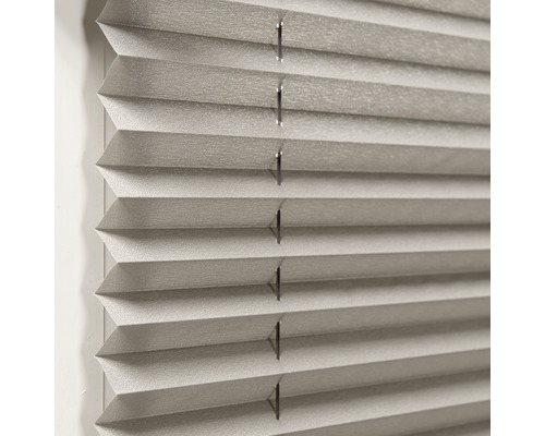 Närbild av en grå plisségardin för fönsterdekoration och ljusreglering