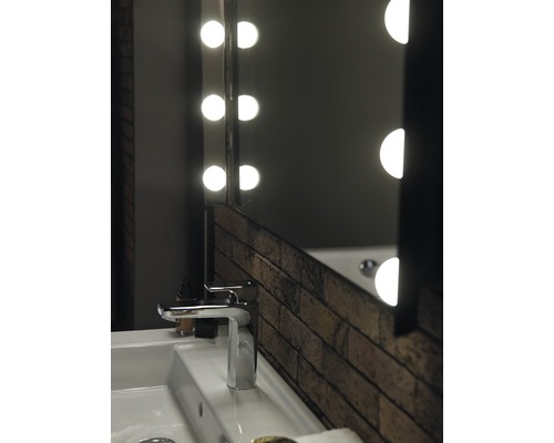 Badrumshandfat med armatur och belyst spegel i tegeldesign