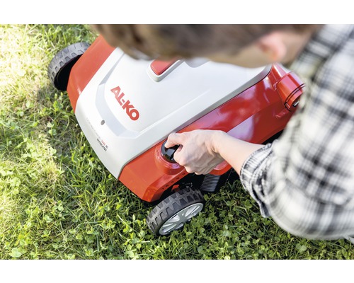 Person startar en Al-ko gräsklippare på en gräsmatta.