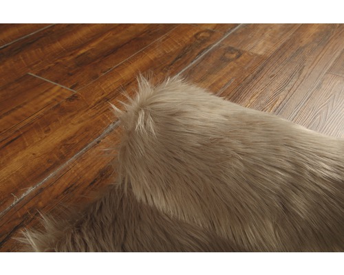 Närbild av en ljusbrun ryamatta på trägolv.