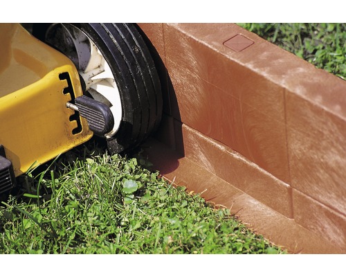 Närbild av en gräsklippare vid en gräsmattekant.