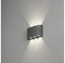Grå vägglampa med ljusstrålar på väggen