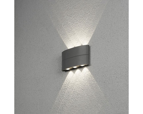 Grå vägglampa med ljusstrålar på väggen