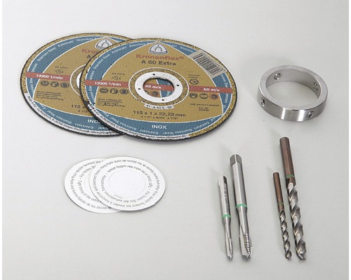 Två kapskivor, en metallring, två gängtappar och två spiralborrar ligger på en ljus yta.