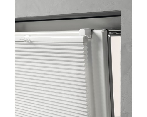 Detaljvy av en vit plisségardin på ett fönster