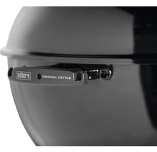 Detaljvy av en Weber klotgrill med lock och handtag