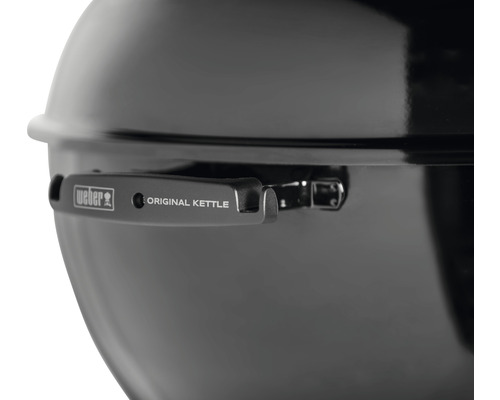 Detaljvy av en Weber klotgrill med lock och handtag