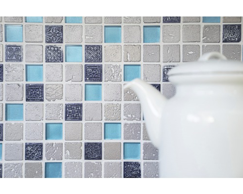 Mosaikplattor med ornament och glasdetaljer i bakgrunden