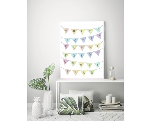 Dekorativ alfabetgirlang som inramad affisch på en hylla