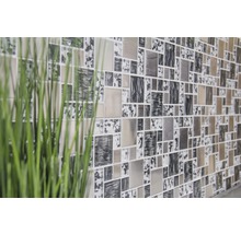 Vägg med kvadratiska mosaikplattor och växtdekoration