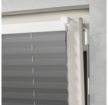 Detaljvy av en grå plisségardin i en fönsterkarm