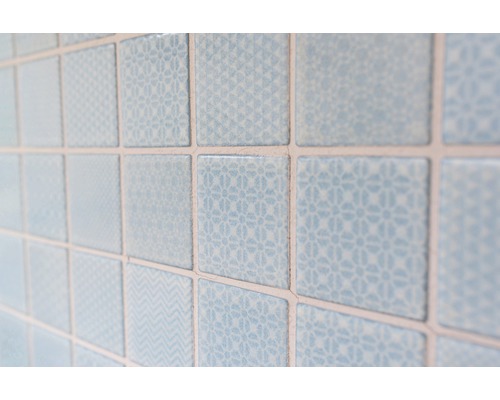 Närbild av ljusblå, kvadratiska väggplattor med olika mönster