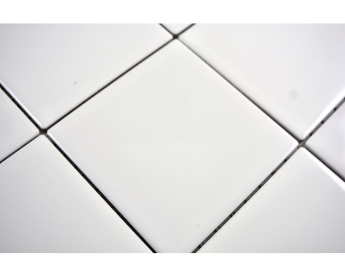 Närbild av vita fyrkantiga plattor med fogar