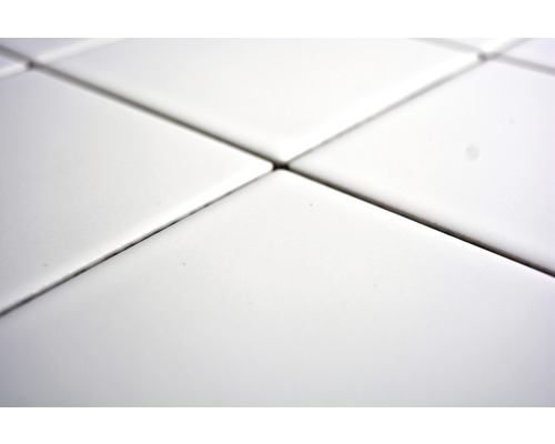 Närbild av vita fyrkantiga plattor med fogar