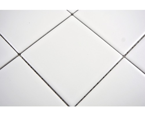 Närbild av vita kvadratiska plattor med fogar