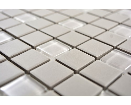 Närbild av mosaikplattor med fyrkantiga grå stenar och transparenta glaselement