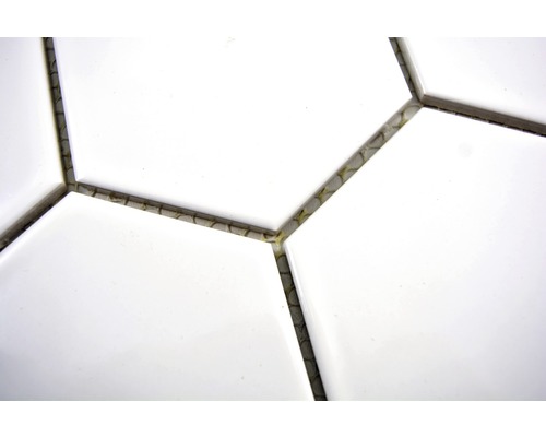 Närbild av vita, hexagonala plattor med fogmassa