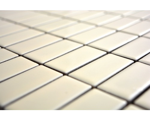 Närbild av rektangulära, glänsande plattor arrangerade i ett upprepande mönster