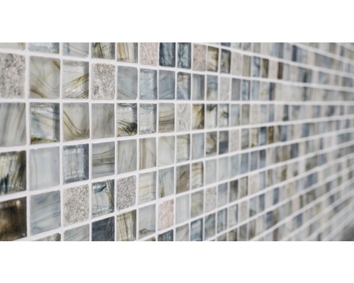 Närbild av en mosaikplatta med fyrkantiga glasbitar.