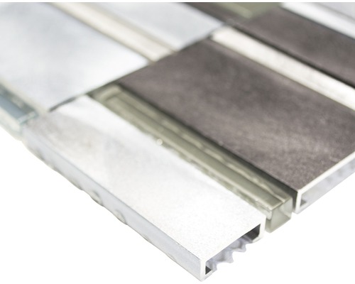 Närbild av en mosaikplatta med element av glas och aluminium