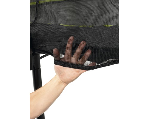 Närbild av ett säkerhetsnät för en studsmatta med en hand som rör nätet.