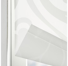 Närbild av en vit rullgardin med mönster i en fönsterram