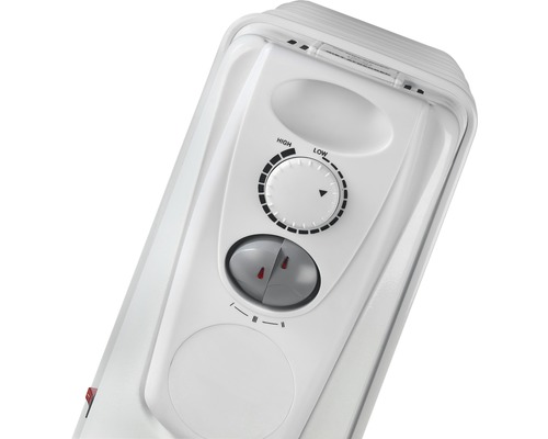 Detaljvy av ett vitt element med vridreglage och strömbrytare för temperaturjustering.