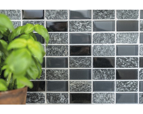 Vägg av mosaikplattor med rektangulära plattor och växt