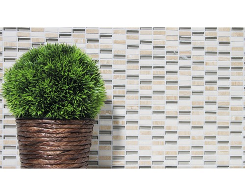 Dekorativ konstgjord växt i kruka mot en mosaikbakgrund