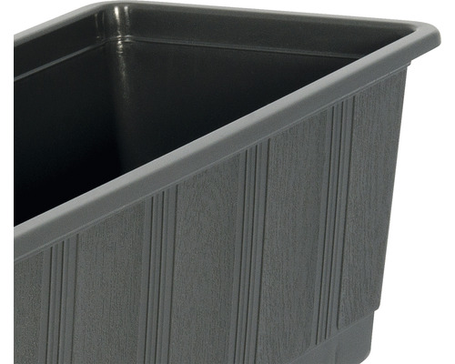 Detaljvy av en grå blomlåda med räfflad textur.