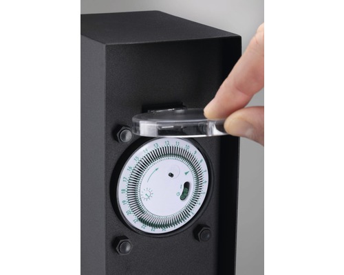 Timer i ett svart hölje med en hand som öppnar det genomskinliga locket.