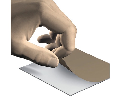 En hand drar bort skyddsfilmen från en platta.