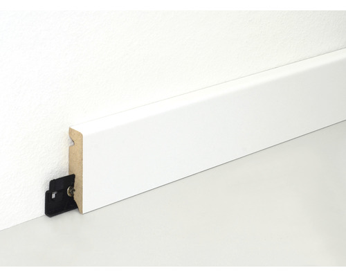 Vit golvlist med fästklämma på en vägg