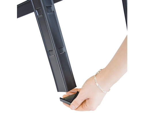 Hand sätter fast ett hörnstycke på en metallhylla