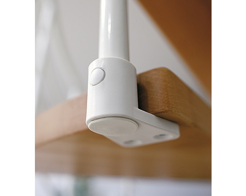 Detaljvy av ett vitt trappräckesfäste på ett trätrappa.