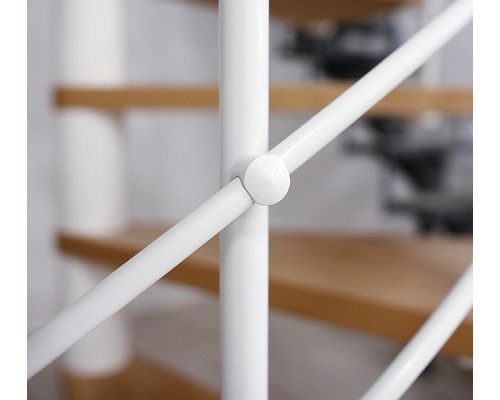 Detaljbild av ett vitt trappräcke med trätrappsteg i bakgrunden