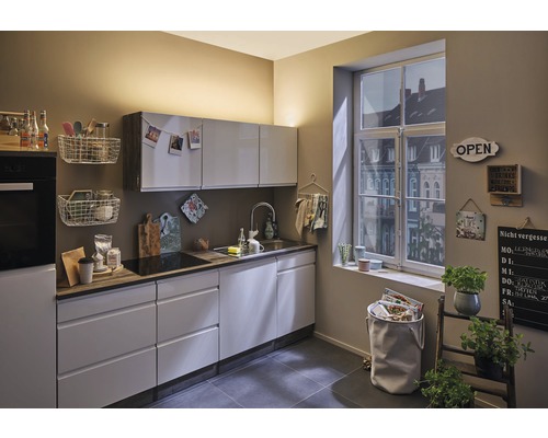 Ljust kök med inbyggda skåp, diskho, fönster och dekorativa element