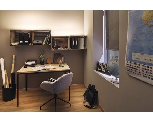 Arbetsrum med skrivbord, stol och vägghyllor av trälådor