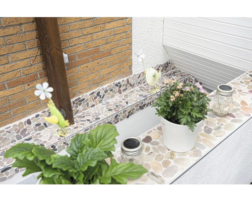 Dekorativa stenplattor förskönar ett uterum med växter och dekorationer.