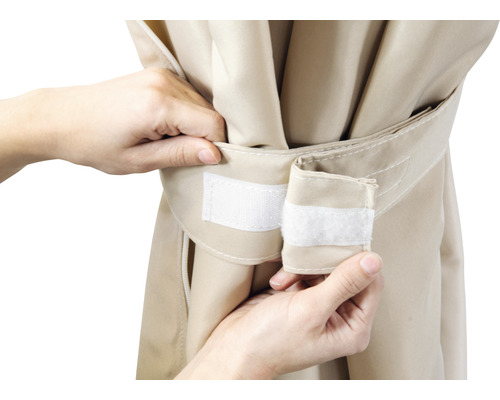 Närbild av en beige markisväv som fästs med kardborreband.