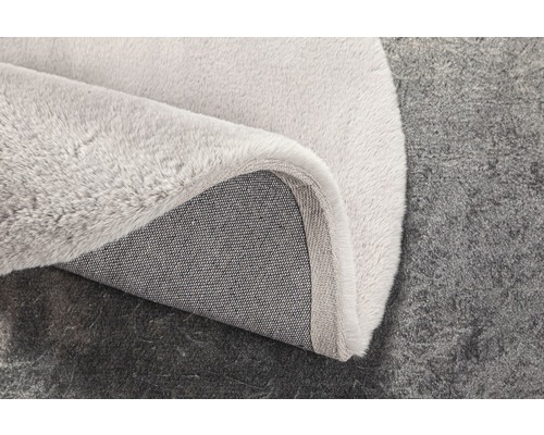 Detaljvy av en ljusfärgad matta med textilbaksida