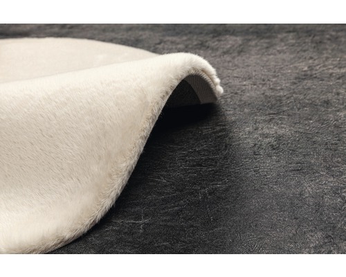 Detaljvy av en rund, ljus matta med hög lugg