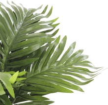 Närbild av en konstgjord palm med gröna blad som dekoration