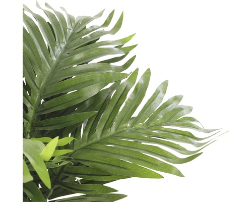 Närbild av en konstgjord palm med gröna blad som dekoration