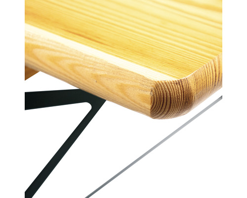 Detaljvy av en bordsskiva i trä med rundad kant och metallram