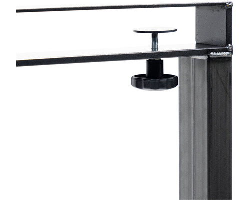 Detaljbild av en svart låsknapp på en metallkonstruktion.