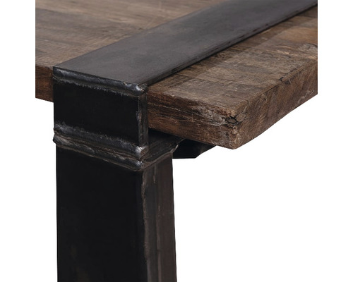 Detaljvy av en bordsskiva i trä med metallkant och bordsben