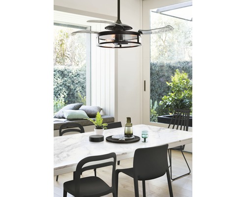 Matsal med takfläkt med belysning och marmorbord med stolar.