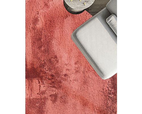 Detaljvy av ett rum med en högflorig matta, en soffa och ett bord