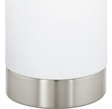 Detalj av en vit bordslampa med metallfot